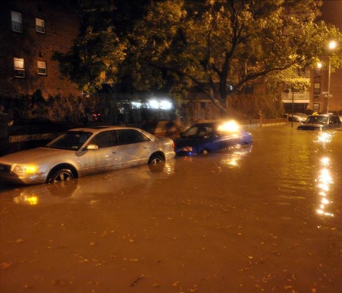 Flooded street causing damage to vehicles.