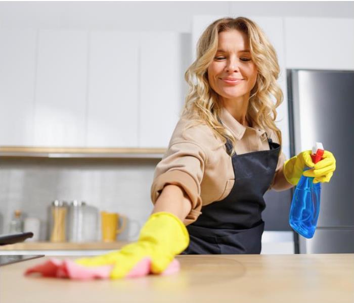 A woman cleaning and disinfecting countertops