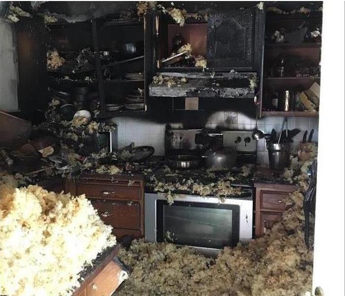 Fallen insulation and debris covering kitchen after a fire